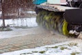 A snowplow removes snow from the sidewalk in the courtyard of a residential building