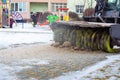 A snowplow removes snow from the sidewalk in the courtyard of a residential building