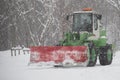 Snowplow removing snow in the street after blizzard. Front view of snowplow service truck and gritter spreading salt on the road s Royalty Free Stock Photo