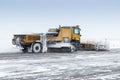 Snowplow truck cleans airport apron in a blizzard