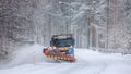 Snowplow truck clearing a snow-covered icy road Royalty Free Stock Photo