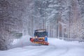 Snowplow truck clearing a snow-covered icy road Royalty Free Stock Photo