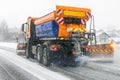 Snowplow truck removing dirty snow from city street or highway during heavy snowfalls. Traffic road situation. Weather forecast