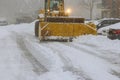 Snowplow trucks remove snow from parking lots following heavy a snowfalls