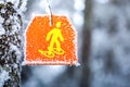 Snowshoes sign hiking marker on tree in winter forest trail