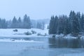 Snowstorm over lake in Alps