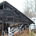 Snowy abandoned burned-out fire wooden black house. Royalty Free Stock Photo