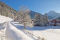 Snowy alpine village in Italy illuminated by sun with mountains in the background Royalty Free Stock Photo