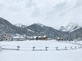 Snowy alpine village in Italy with mountains in the background Royalty Free Stock Photo