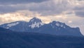 Snowy Alps at cloudy sunset with rays of light through clouds Royalty Free Stock Photo