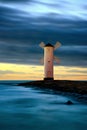 Snowy Baltic Sea Scene. Beautiful Sunset Over A Windmill-shaped Lighthouse. Swinoujscie, Poland.
