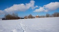 Snowy bavarian winter landscape with traditional church, blue sky with clouds