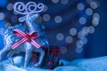 Snowy Blue Closeup Reindeer Ornament Christmas Bokeh Background.