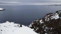 Snowy blue winter landscape of Arctic ocean and snow covered stony shore. Footage. Aerial of the coastline, cliffs Royalty Free Stock Photo