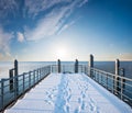 Snowy boardwalk at the seaside, blue sky with clouds Royalty Free Stock Photo