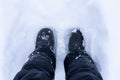 Snowy Boots. Top view of shoes or boots footprint in fresh snow. Winter season. Focus on Legs.