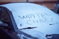 Snowy car windshield with winter check inscription in winter