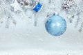 Snowy christmas background with fir tree branch decorated with blue ball, drum toy and star Royalty Free Stock Photo
