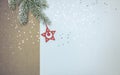 Snowy christmas tree branch with red wooden star and silver star confetti Royalty Free Stock Photo