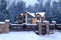 Snowy cottage in forest. Winter landscape with yellow wooden luxury house.