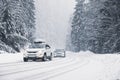 Snowy country road with cars on winter day Royalty Free Stock Photo