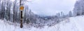 Snowy crossroads at the signpost under the view of the Medvedi Kamen in Jeseniky mountains in the Czech Republic