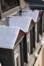 Snowy dormer windows at old building