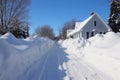 snowy driveway with cleared path and piled snow