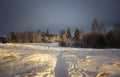 Snowy field at sunset in winter. Beautiful sky. The sky before the snow. Gray sky and sun. Evening sun Winter sunset Royalty Free Stock Photo