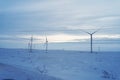 Alternative energy sources. Eco-friendly electricity. Snowy field and wind turbine sunrise in winter. Aerial view of nature in Royalty Free Stock Photo