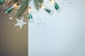 snowy fir tree branch decorated with modern holiday lights and decorative glass stars. background with silver confetti