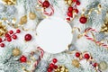 Snowy fir tree, round paper blank and Christmas decorations on white wooden table top view. Flat lay.