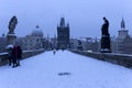 Snowy foggy Prague Old Town with Bridge Tower and St. Francis of Assisi Cathedral from Charles Bridge with its baroque Statues, Cz