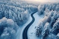 Snowy forest landscape aerial perspective of curvy, winding road