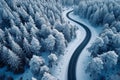 Snowy forest landscape aerial perspective of curvy, winding road