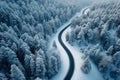 Snowy forest landscape aerial perspective of curvy, winding road