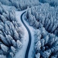 Snowy forest landscape aerial perspective of curvy, winding road