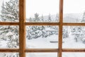 Snowy forest trees in the snow outside the window with a wooden