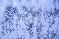 Snowy frosty pattern on a glass surface. Frost on the glass of the window. Frosty window. Snowflakes on the glass in winter. Royalty Free Stock Photo