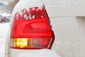 Snowy and glowing tail light of the car. Safety on winter roads Royalty Free Stock Photo