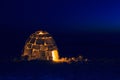 A snowy house called an igloo at sunset. Royalty Free Stock Photo