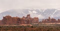 Snowy mountains behind rock formations in Arches National Park