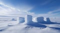Snowy landscape featuring several tall, rectangular ice formations standing on a flat, expansive snow-covered terrain