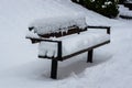 Snowy landscape. The park bench is covered with white thick snow. Winter day Royalty Free Stock Photo