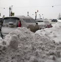 Snowy landscape, snow piles and mountains of snow on snow-covered roads and streets of Saint-Petersburg