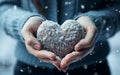 Snowy Love Young Girls Hands Holding Heart. Hands in mittens holding a snow heart in the snow Royalty Free Stock Photo