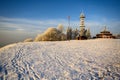 Snowy meadow,trees with hoarfrost, tower and cottage, hill Kozakov Royalty Free Stock Photo