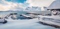 Snowy morning view of Vestvagoy island with small pier, boat and wooden dock. Royalty Free Stock Photo