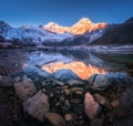 Snowy mountain with illuminated peaks is reflected in lake Royalty Free Stock Photo