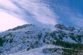 Snowy mountain peaks. Mountain landscape. Winter in the mountains. Blue sky and clouds. White snow. Royalty Free Stock Photo